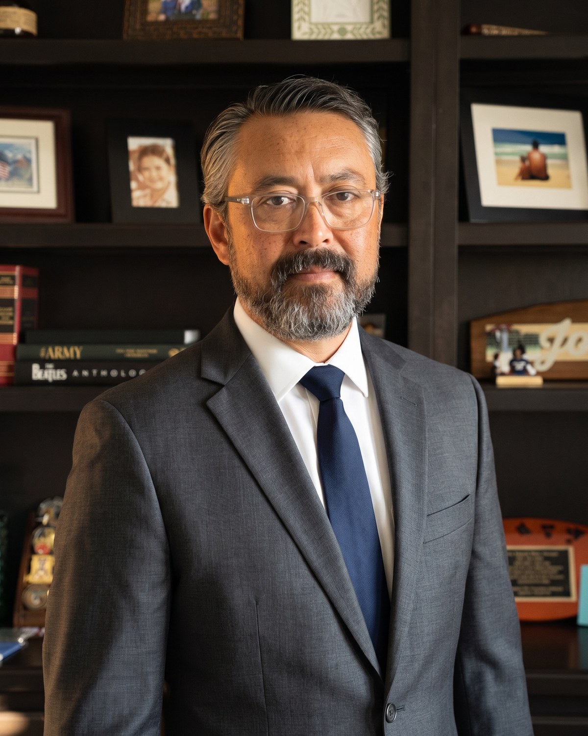 Elton Johnson, Kentucky-licensed attorney, in his Elizabethtown office. Charcoal suit, navy tie, bookshelf with family photos and military mementos.